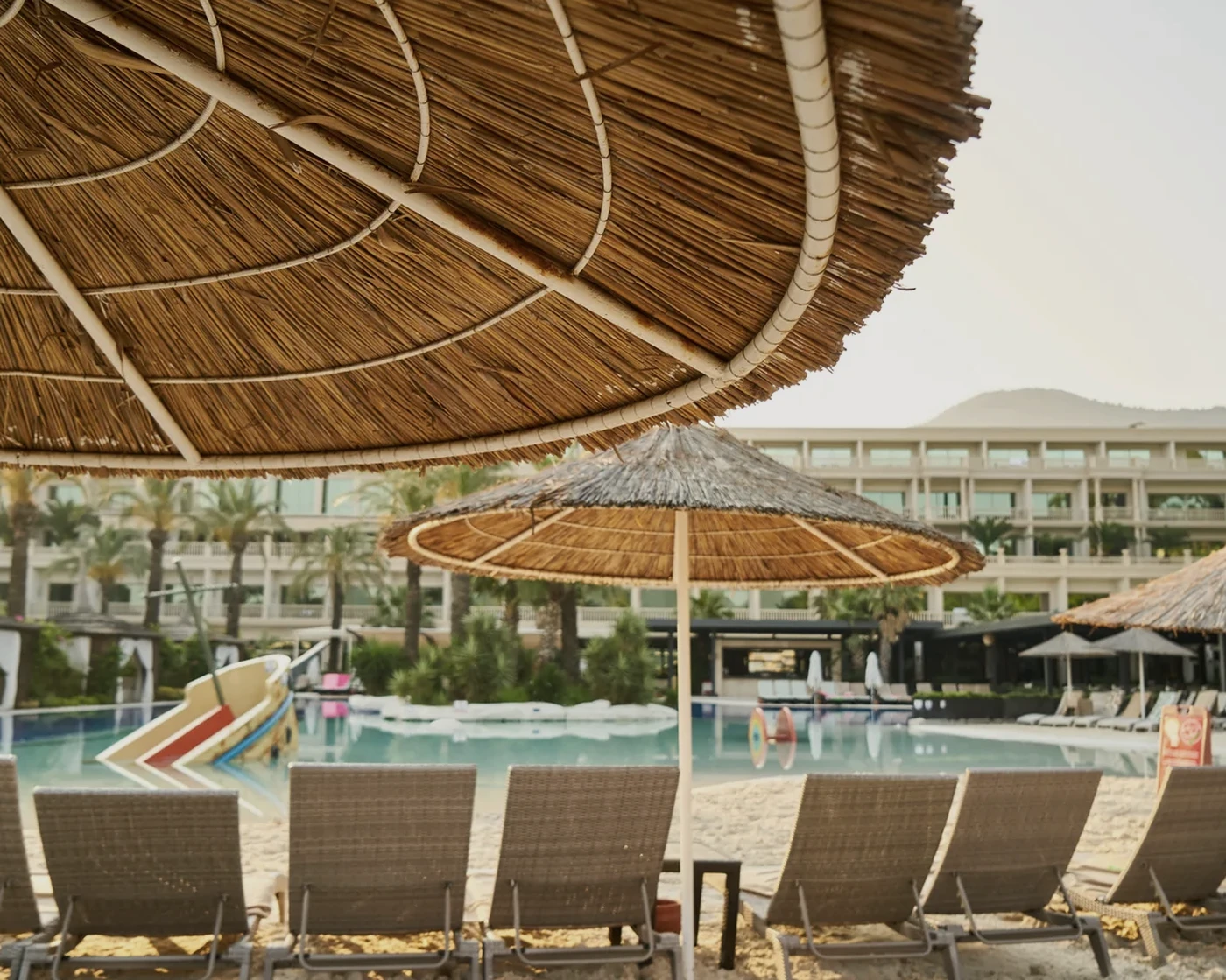 Elegant resort scene with loungers and a refined coastal setting.