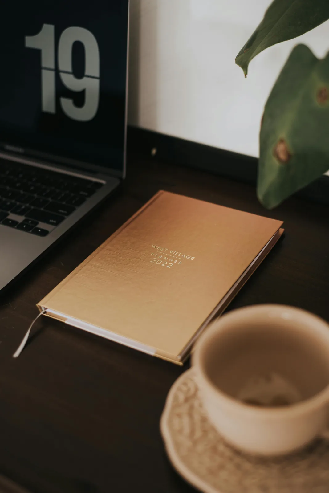 Open planner beside travel accessories on a table.